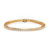 Gold tennis bracelet with 4 carats of pear cut diamonds in a sleek, elegant line design on white backgrund