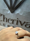 Diamond ring on a hand with 'Cheriva' jewelry brand name in the background
