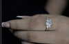 Close-up of a hand wearing a diamond ring with a blurred background