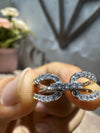 Silver ring with diamond accents held by a hand against a blurred background