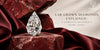 Pear shaped lab grown diamond displayed on red stone with burgundy satin for a premium Cheriva Jewels jewelry guide.