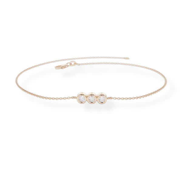Rose gold bracelet with three diamonds on a white background