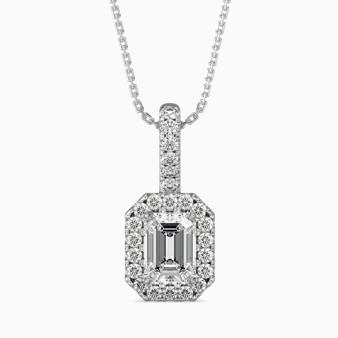 An emerald cut diamond pendant with a halo of smaller diamonds set in a white gold chain.
