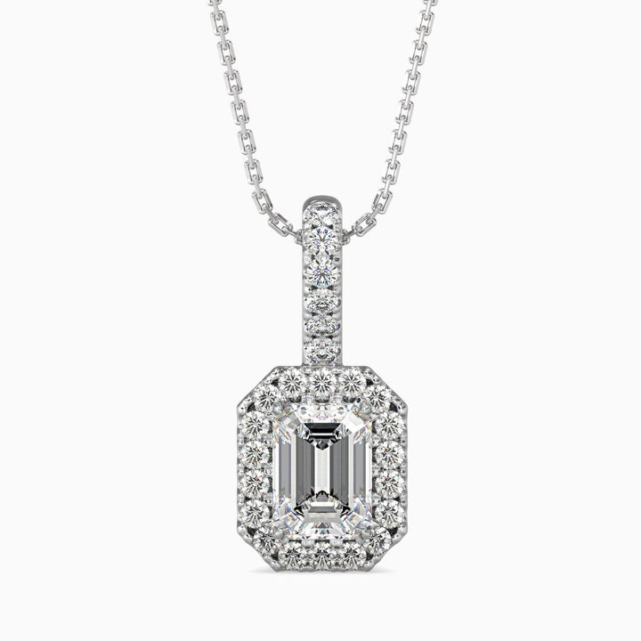 An emerald cut diamond pendant with a halo of smaller diamonds set in a white gold chain.