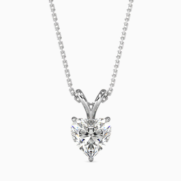 A heart-shaped diamond pendant set in a white gold or silver chain, with a clear and sparkling stone.