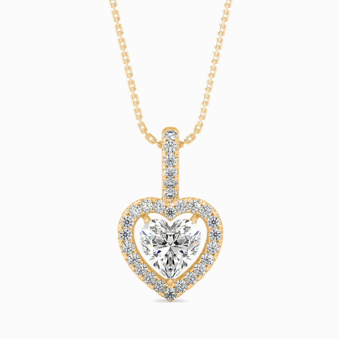 Heart-shaped diamond pendant on a gold chain on a white background