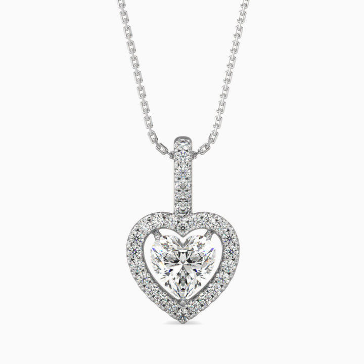 A heart-shaped halo pendant with a diamond centerpiece, surrounded by smaller diamonds on the halo, set in a white gold chain.