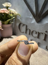 Diamond ring held between fingers with 'Cheri' branding in the background