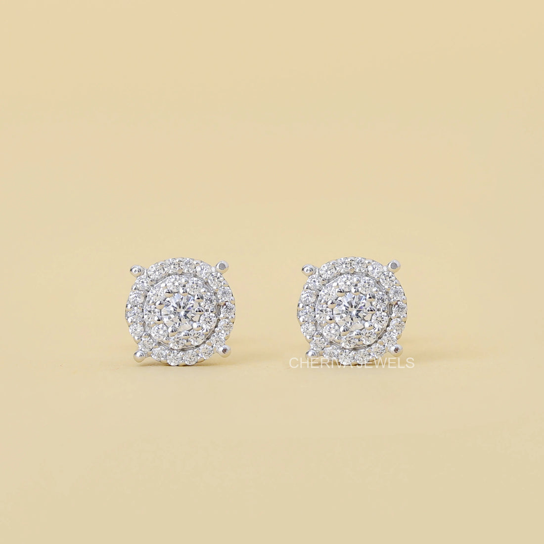 Pair of diamond earrings on a beige background