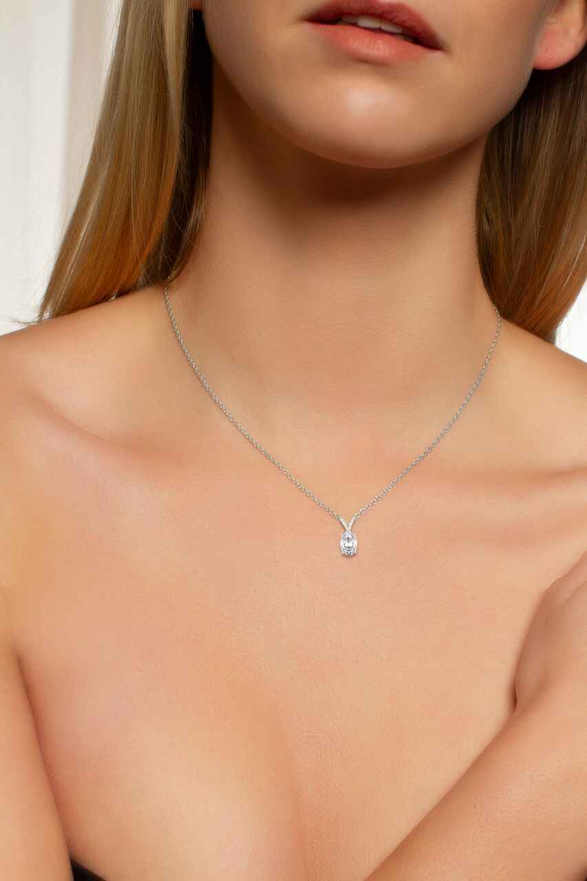 Necklace with a small pendant on a model against a neutral background