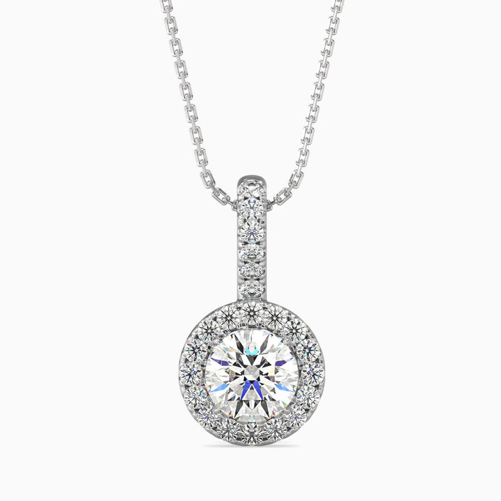 A round halo pendant with a central diamond surrounded by smaller diamonds, set in a white gold or silver chain.
