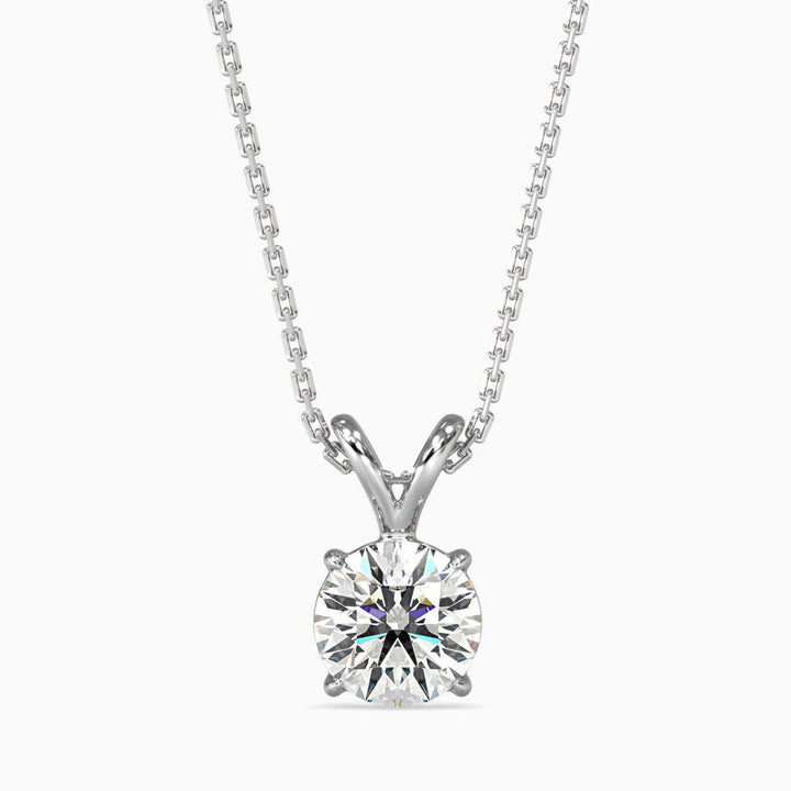 A round cut diamond pendant with a chain, set against a white background.