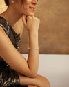 Woman wearing a delicate bracelet with a neutral background